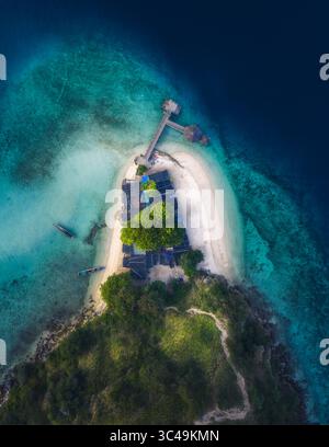 Blick aus der Vogelperspektive auf eine tropische Insel mit einem lebendigen grünen Baldachin gegenüber dem türkisfarbenen Wasser und dem weißen Sandstrand, Komodo Island, East Nusa Tenggara, Indonesien. Stockfoto