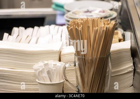 Nahaufnahme von Einweg-Utensilien und Servietten in einer Cafeteria-Umgebung Stockfoto