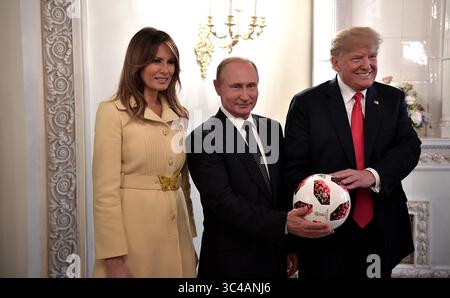 16. Juli 2018 – Helsinki, Finnland: Der russische Präsident WLADIMIR PUTIN, Mitte, überreicht US-Präsident DONALD J. TRUMP einen Fußball der FIFA-Weltmeisterschaft 2018, während First Lady MELANIA TRUMP den Abschluss des Gipfels zwischen den USA und Russland im Präsidentenpalast am 16. Juli 2018 in Helsinki, Finnland, ansieht. (Bild: © Kreml Pool via ZUMA Wire) Stockfoto