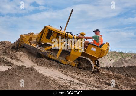 7. September 2024 – Aldtsjerk-Niederlande: Mann, der einen alten Caterpillar D2-Bulldozer auf einem Sandberg während einer historischen Erdbewegungsdemonstration fährt i Stockfoto