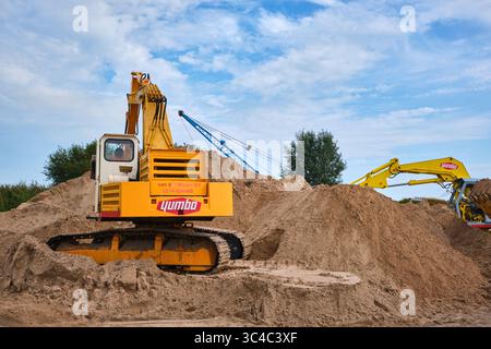 7. September 2024 - Friesland-Niederlande: Zwei klassische Yumbo-Bagger, die auf einem Sanddepot arbeiten, mit sichtbaren Raupenketten, mechanischen Armen A Stockfoto