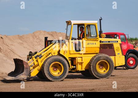 7. September 2024 – Aldtsjerk-Niederlande: Der alte John Deere 544-A Radlader aus den 1970er Jahren beladen einen alten Kipplader in einem Sandbruch während eines Stockfoto