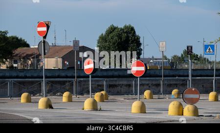 Mehrere Verkehrsverbotsschilder mit gelben Barrieren auf der Straße Stockfoto
