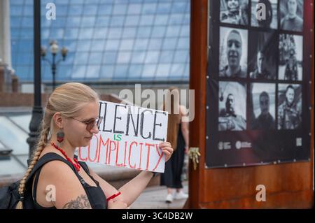 Kiew, Ukraine - 28. Juli 2025: Aktivist hält ein Schild mit der Aufschrift Schweigen ist Mittäterschaft während eines Protestes anlässlich des dritten Jahrestages des Angriffs auf das Gefängnis Oleniwka. In der Nacht vom 28. Auf den 29. Juli 2022 beschossen die Russen die Gefängniskolonie Wolnovakha in der Nähe des besetzten Oleniwka. Mindestens 53 ukrainische Gefangene aus Asovstal wurden bei dem Terroranschlag getötet und mehr als 130 verletzt. Quelle: ARTEM HVOZDKOV/Alamy Live News Stockfoto