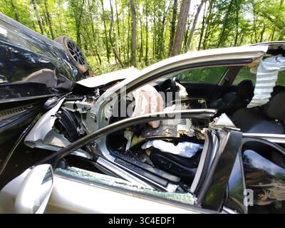 Im Wald ereignete sich ein schwerer Autounfall, in dem die Trümmer der zertrümmerten Fahrzeuge verstreut waren. Stockfoto