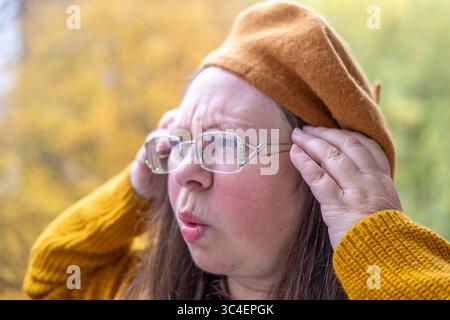 Verstörte reife Frau mit schmerzhaftem Ausdruck, Migräne-Attacke, schwerer Migräne, Kopfschmerzen, schmerzhaftem Ausdruck, Migräneattacke Stockfoto