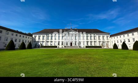 Schloss Bellevue in Berlin, die offizielle Residenz des Bundespräsidenten, von vorne gesehen mit seiner neoklassizistischen Fassade und gepflegtem Rasen. Stockfoto