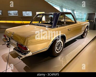 Klassisches goldenes Mercedes-Benz SL Pagoda Coupé mit schwarzem Hardtop, Rückansicht, in eleganter Beleuchtung. Stockfoto