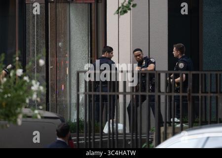New York, Usa. Juli 2025. NYPD-Offiziere suchen Deckung hinter einer Säule neben Glas, die von Einschusslöchern durchbrochen ist, als sie auf einen aktiven Schützen in der 345 Park Ave in New York City reagieren. Staatliche und lokale Strafverfolgungsbehörden reagieren auf einen aktiven Schützen in der 345 Park Ave in New York City. Ein Polizist und zwei Zivilisten wurden erschossen. Quelle: SOPA Images Limited/Alamy Live News Stockfoto