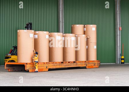 Gabelstapler, der große Papierrollen in Lagergebäuden für Druckindustrie und Logistik transportiert Stockfoto
