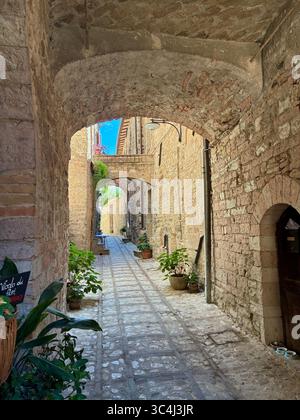 Die engen Gassen von Spello in der Region Umbrien in Italien sind mit bunten blühenden Pflanzen in Töpfen dekoriert Stockfoto