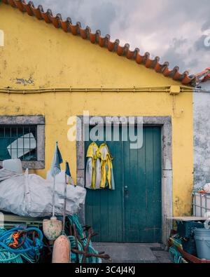 Traditionelles Portugiesisches Fischerhaus Mit Gelben Regenmänteln Und Ausrüstung In Coastal Village. Maritimes Erbe, Fisherman Storage, Northern Portugal S Stockfoto