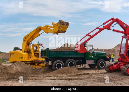 7. September 2024: Aldtsjerk-Niederlande: Oldtimer-Bagger laden während einer von organisierten Maschinenvorführung Sand in einen klassischen Muldenkipper Stockfoto