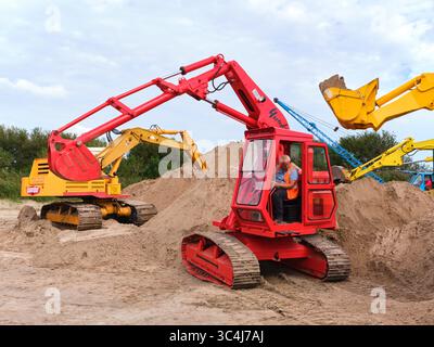 7. September 2024 - Friesland-Niederlande: Zwei klassische Yumbo-Bagger, die auf einem Sanddepot arbeiten, mit sichtbaren Raupenketten, mechanischen Armen A Stockfoto