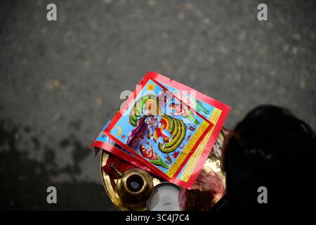 Kathmandu, Nepal. Juli 2025. Ein nepalesischer Anhänger bereitet sich darauf vor, während des Nag Panchami Festivals in Kirtipur, Kathmandu, Nepal, am 29. Juli 2025 ein Poster eines Schlangengottes am Haupteingang eines Hauses zu kleben. Am folgenden Tag verehren Menschen in Nepal, Indien und anderen hinduistischen Ländern Schlangen. Gläubige feiern dieses fest mit Glauben und Leidenschaft. An diesem Tag verehren die Gläubigen Lord Shiva, den Halter der Schlange, die sie für verheißungsvoll halten. (Foto: Narayan Maharjan/NurPhoto)0 Credit: NurPhoto SRL/Alamy Live News Stockfoto
