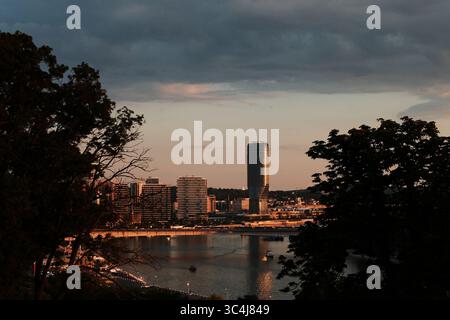 Blick auf den Sonnenuntergang der Belgrader Waterfront mit moderner Skyline und Glashochhaus mit goldenem Licht. Belgrad, Serbien - 12. Juni 2025. Stockfoto