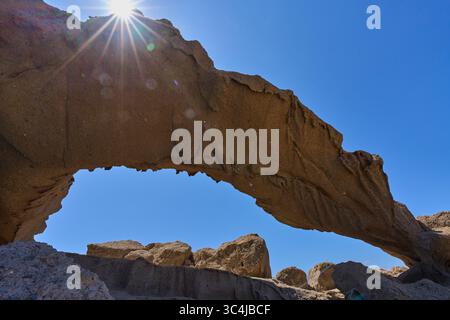 Vulkanischer Tuffbogen des Arco de Tajao auf Teneriffa, beleuchtet von Sonnenaufgang vor klarem blauem Himmel Stockfoto