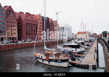 Danzig, Polen - 04-07-2025 - Yachten und Boote liegen entlang des Kanals in einer Hafenstadt gegenüber renovierten historischen Häusern Stockfoto