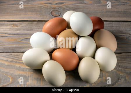 Eine Sammlung frischer, biologischer Hühnereier auf einem rustikalen Holztisch, die eine natürliche und häusliche Ästhetik zeigen. Perfekt für die Werbung für fa Stockfoto