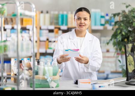 Apothekerin arbeitet am Computer in Apothekennähe Stockfoto