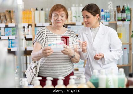 Frau Käuferin scannt Pillen-qr-Code mit Frau Apothekerin Stockfoto
