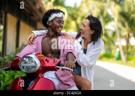 Reines Glück. Ein junges, vielseitiges, multiethnisches Paar genießt jeden Moment ihres tropischen Urlaubs Stockfoto