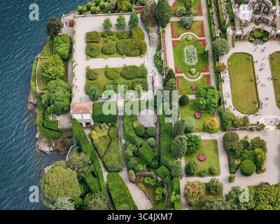 Die gepflegten Gärten von Isola Bella aus der Vogelperspektive stehen im Kontrast zum tiefblauen Wasser des Lago Maggiore, Stresa, Piemont, Italien. Stockfoto