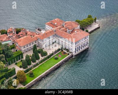 Blick aus der Vogelperspektive auf den großen Palast von Isola Bella, seine terrassenförmig angelegten Gärten, die in das glitzernde Wasser kaskadieren, ein malerisches Juwel inmitten des Sees, Isola Bella, Piemont, Italien. Stockfoto