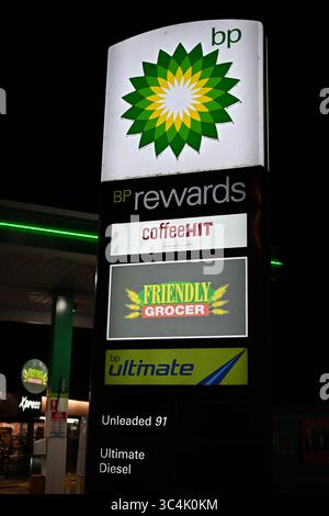 Beleuchtetes Schild für die BP-Tankstelle, mit dem Logo des Friendly Grocer Convenience Store, bei Nacht Stockfoto