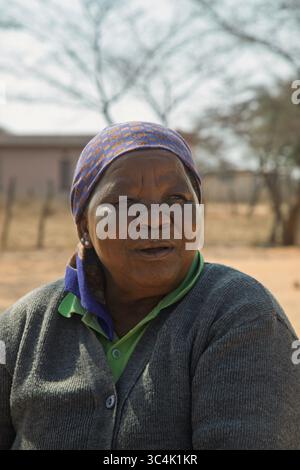 Porträt der glücklichen übergewichtigen alten afrikanerin im Dorf, Botswana ländliche Gegend, draußen im Hof, Haus im Hintergrund Stockfoto