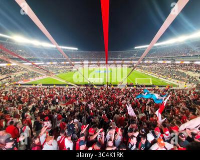 River Plate Fans schwenken Flaggen und Inflatables während eines Nachtfußballspiels im Estadio Monumental in Buenos Aires, Argentinien. Stockfoto