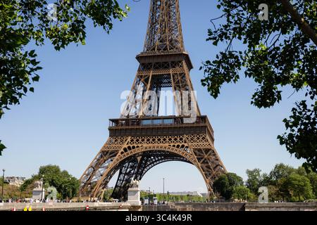 Blick auf den Eiffelturm durch üppig grüne Bäume Sommertag Paris, Frankreich Stockfoto