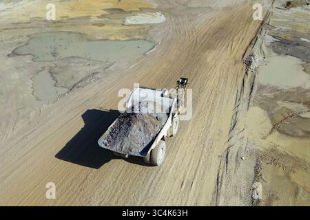 Aus der Vogelperspektive eines kolossalen Müllwagens, der Erz über die zerklüftete, abgestufte Landschaft Erzbergs transportiert, eine Symphonie aus Erdtönen und Industriemächte, Eisen Stockfoto