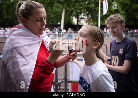 London, Großbritannien. Juli 2025. Junge England-Fans machen sich in der Mall für die Trophäenparade der Lionesses Euro 2025 fertig. Der Bus mit offenem Oberdeck fuhr in einem langsamen Tempo entlang der Mall und endete am Buckingham Palace, wo eine inszenierte Zeremonie stattfand. Guy Corbishley/Alamy Live News Stockfoto