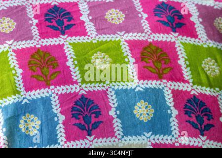 Nahaufnahme aus weichem Baumwollgewebe mit wunderschönen Blumenmustern. Ein farbenfroher und detaillierter Texturhintergrund mit abstraktem Blumendesign, Stockfoto