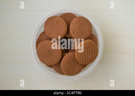 Köstliche Kekse mit Schokoladengeschmack in einem Plastikbehälter. Leckere runde Plätzchen, perfekt zum Snack, Frühstück oder Dessert. Draufsicht. Stockfoto