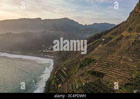 Aus der Vogelperspektive treffen auf die rauschenden Wellen, wo Terrassen-Hänge zu einem dunklen Sandstrand, La Gomera, Kanarischen Inseln, Spanien, herabstürzen. Stockfoto