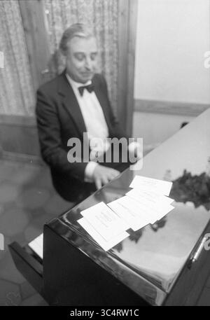 Neujahrsempfang, City, Haarlem, 09-01-1992 Whizgle News, Dutch Desk, Niederlande, 1950-2000 Ein Mann in formeller Kleidung spielt Klavier, trägt eine Fliege und legt ordentlich angeordnete Noten oder Noten auf das Instrument vor sich. Stockfoto