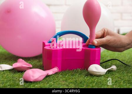 Frau, die einen Ballon mit Luftpumpe im Haus aufbläst, Nahaufnahme Stockfoto