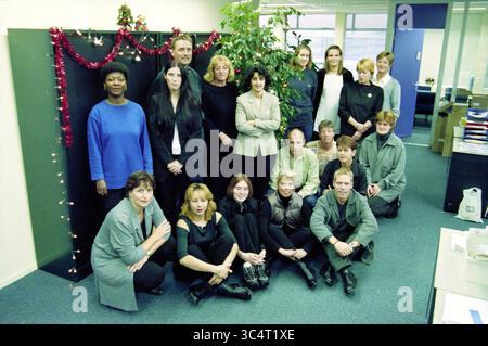 Gruppen Haarlem Zilveren Kruis, Achmea, Haarlem, Niederlande, 08-11-2000 Whizgle News, Dutch Desk, Niederlande, 1950-2000 Eine Gruppe von Kollegen versammelte sich in einer festlichen Büroumgebung und posierte mit einem Lächeln. Die Kulisse ist mit Weihnachtslichtern und Grün dekoriert, was eine fröhliche Atmosphäre schafft. Mitarbeiter mit verschiedenen Rollen und Stilen stehen und sitzen in einer entspannten Anordnung und zeigen ein Gefühl von Kameradschaft und Teamgeist. Stockfoto