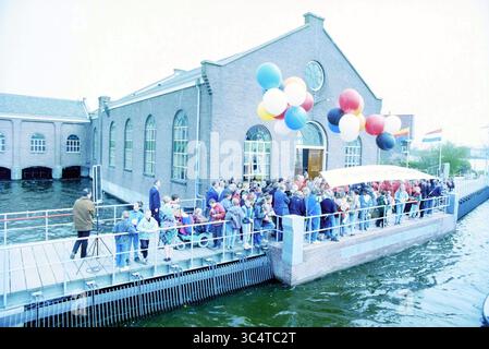 Wiedereröffnung der Pumpstation Sp'Dam, Spaarndam, 21.04.1994 Whizgle News, Dutch Desk, Niederlande, 1950-2000 Eine große Menschenmenge versammelt sich auf einem Bahnsteig in der Nähe einer Wasserstraße, um eine Veranstaltung vor einem Backsteingebäude mit großen Fenstern zu feiern. Bunte Ballons schweben über der Versammlung, während Flaggen aus verschiedenen Nationen in der Nähe zu sehen sind. Stockfoto