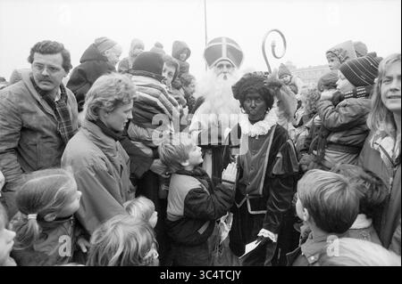 Ankunft von Sint Heemstede, St. Nikolaus, Sinterklaas, Heemstede, Niederlande, 16-11-1985 Whizgle News, Dutch Desk, Niederlande, 1950-2000 Ein festliches Treffen mit einer Gruppe von aufgeregten Kindern und Erwachsenen, mit einer Figur in traditioneller Kleidung, die als St. Nikolaus gekleidet ist, in der Mitte, begleitet von einer Figur in traditioneller Kleidung, die eine Atmosphäre des Feierns und der Freude schafft. Stockfoto