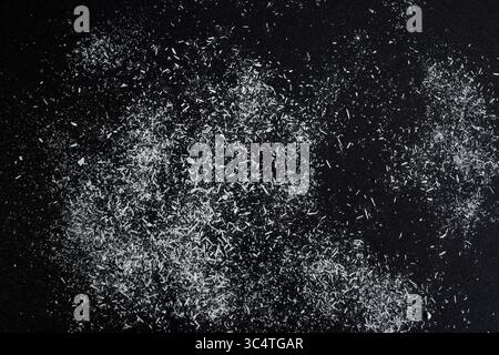 Weiße Acrylpastellspäne auf schwarzem Papier, abstrakter Hintergrund Stockfoto