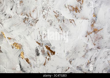 Weiße Spachtelpaste gemischt mit schwarzer Tinte, abstrakte Nahtdetails von Spachtelstrichen auf der Renovierung der Wände mit goldenem Stuck Stockfoto