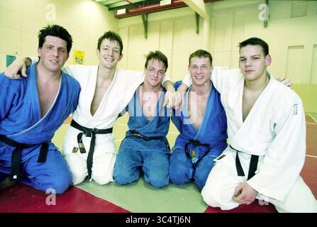 Judo: Team van bavel, Haarlem, Niederlande, 05-01-1998 Whizgle News, Dutch Desk, Niederlande, 1950-2000 fünf junge Männer in Judo-Gi, zwei in Blau und drei in weiß, lächeln und posieren zusammen auf einer Matte. Sie tragen schwarze Gürtel und scheinen ein erfolgreiches Training oder eine Leistung in ihrem Sport zu feiern. Stockfoto
