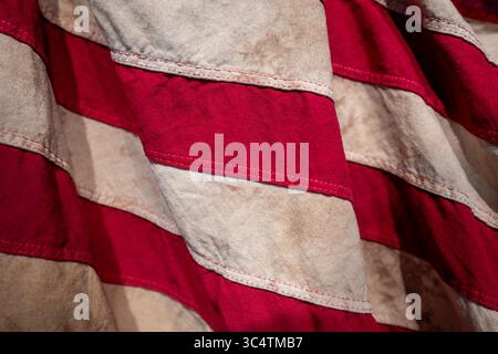 VEREINIGTE STAATEN – Eine detaillierte Ansicht einer Reproduktion der Flagge aus der Zeit des Unabhängigkeitskriegs mit den markanten roten und weißen Streifen, die die amerikanischen Kolonien symbolisierten. Diese Flaggenart mit ihren abwechselnden roten und weißen horizontalen Streifen gehörte zu den frühesten Mustern, die während der Amerikanischen Revolution (1775–1783) verwendet wurden. Die Reproduktion fängt die historischen Textilmuster und die Färbung der Flaggen aus der Zeit ein, als die Vereinigten Staaten für die Unabhängigkeit von Großbritannien kämpften. Stockfoto