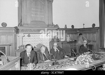 Installation von Bürgermeister Machielsen Zandvoort, Bürgermeister, 05-10-1977 Whizgle News, Dutch Desk, Niederlande, 1950-2000 Eine Gruppe von vier Männern, die an einem langen Tisch in formeller Umgebung sitzen, mit dekorativer Kulisse und einem Blumenmuster davor. Sie scheinen in einer ernsthaften Diskussion oder Diskussion zu sein, wobei einige Mitglieder nach unten schauen oder tief in Gedanken sind. Stockfoto