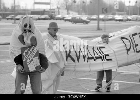 Opening G-Pier, Schiphol, 21.04.1992 Whizgle News, Dutch Desk, Niederlande, 1950-2000 Eine Gruppe von Demonstranten hält ein großes Banner mit der Aufschrift „Kwiade Piek“ und trägt Schilder, die ihre Botschaft ausdrücken, während ein Teilnehmer ein Gespensterkostüm trägt. Die Szene spielt in einem offenen Bereich, wahrscheinlich in der Nähe eines Einkaufszentrums. Stockfoto