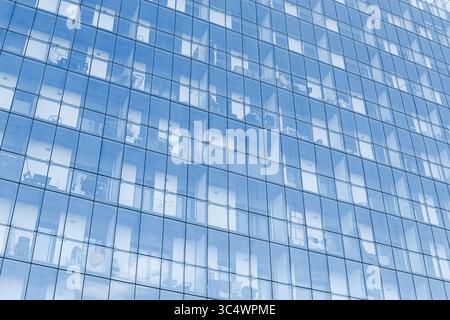 Moderne Bürofassade aus Glas. Reflektierende Fenster mit Himmel. Moderne Architektur. Außenansicht des Firmengebäudes. Blaue Spiegelfläche. Städtische Landstriche Stockfoto