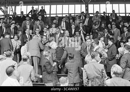VSV - SHS, Football, 24-09-1961 Whizgle News, Dutch Desk, Niederlande, 1950-2000 Eine große Menschenmenge, die in 1960er-Jahre-Kleidung gekleidet ist, füllt eine Tribüne, die sich mit Gesprächen und Bewegungen beschäftigt. Einige Personen stehen, während andere sitzen, wodurch eine dynamische Szene sozialer Interaktion entsteht. Die Atmosphäre deutet auf ein bedeutendes Ereignis oder eine Versammlung hin, mit vielen Gesichtern, die in Richtung Zentrum gerichtet sind. Stockfoto